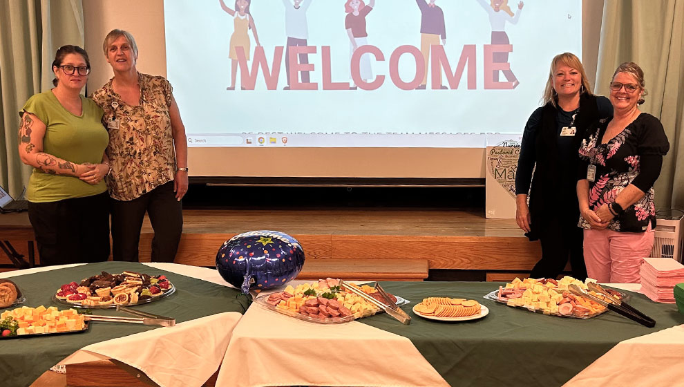 photo: four women standing at buffet table