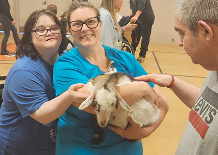 photo: three people petting a goat