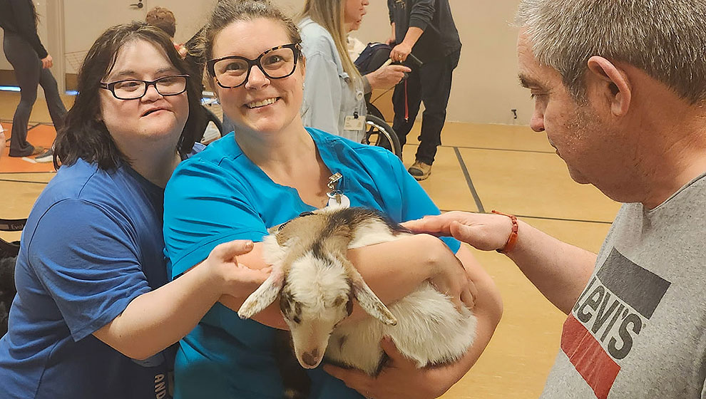 photo: three people petting a goat