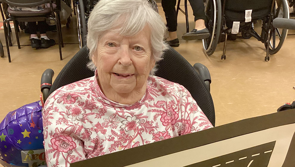 photo: elderly woman hold back-to-school poster