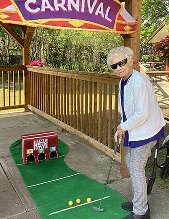photo: elderly woman playing mini-putt