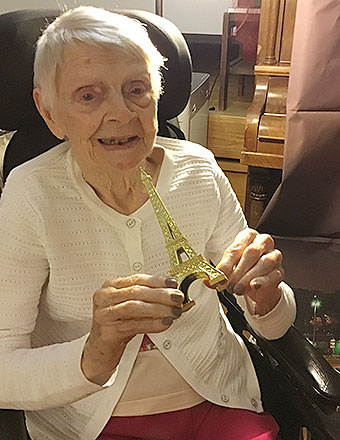 photo: elderly woman holding mini eiffel tower
